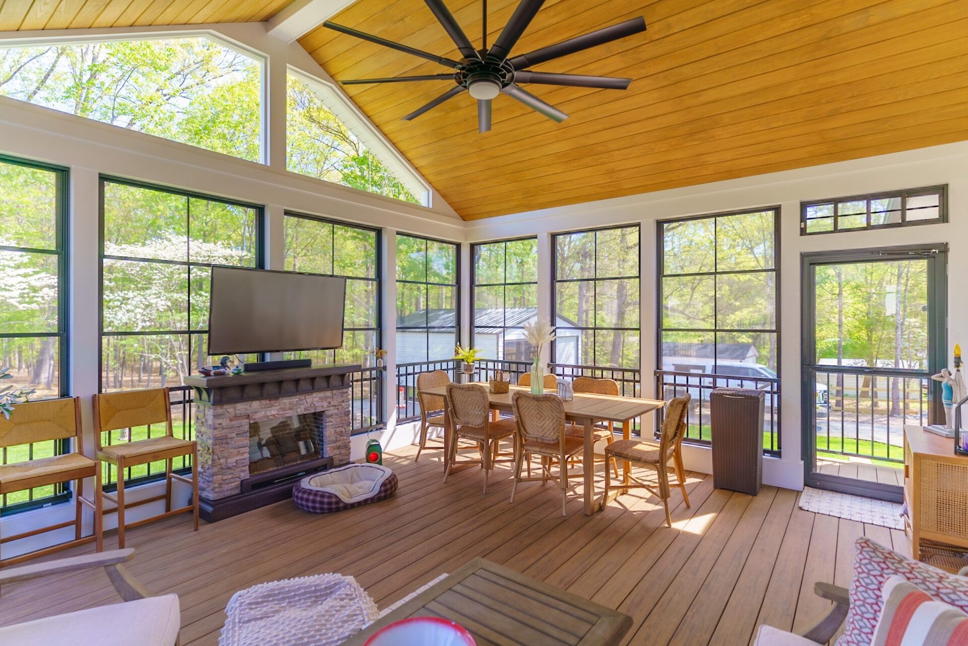 Vaulted screened porch with wood ceiling, composite deck, and stone fireplace custom built by Carolina Decks in the Charlotte, NC area.