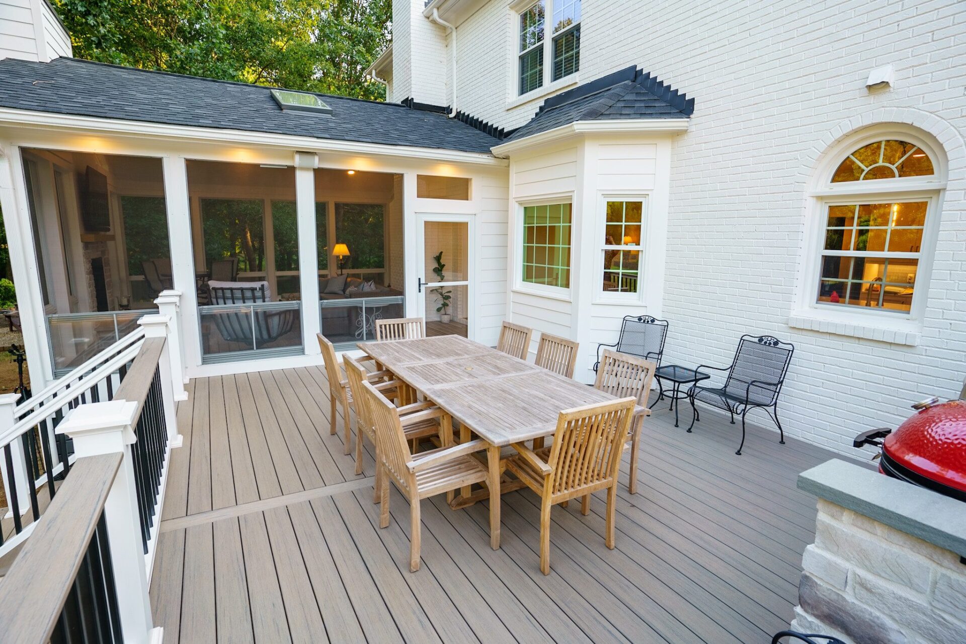 Screened porch and composite deck, with railing, beside white brick home, custom built by Carolina Decks in the Charlotte, NC area.