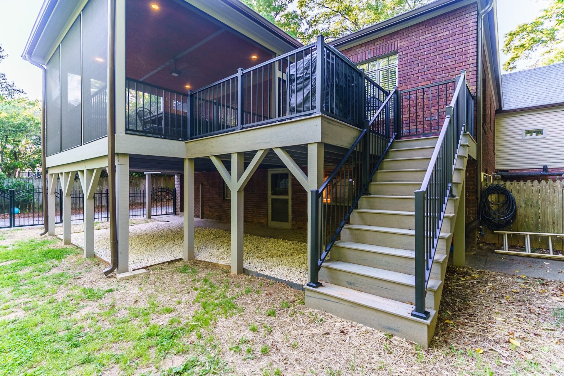 Elevated screened porch and composite deck with modern black metal railings and stairs, custom built by Carolina Decks in the Charlotte, NC area.