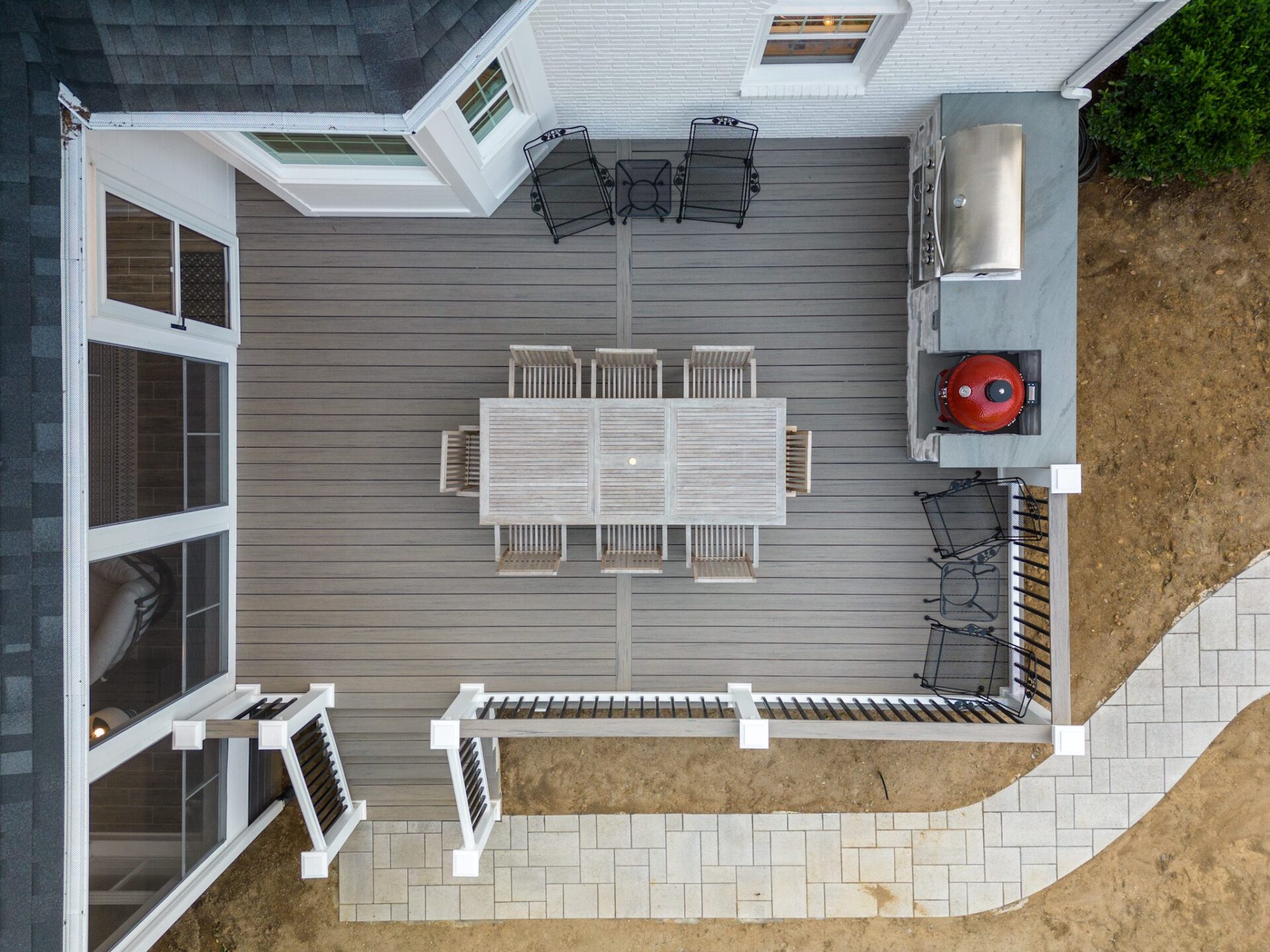 Large composite deck, screened porch, stone outdoor kitchen, and modern railing, custom built by Carolina Decks in the Marvin neighborhood.
