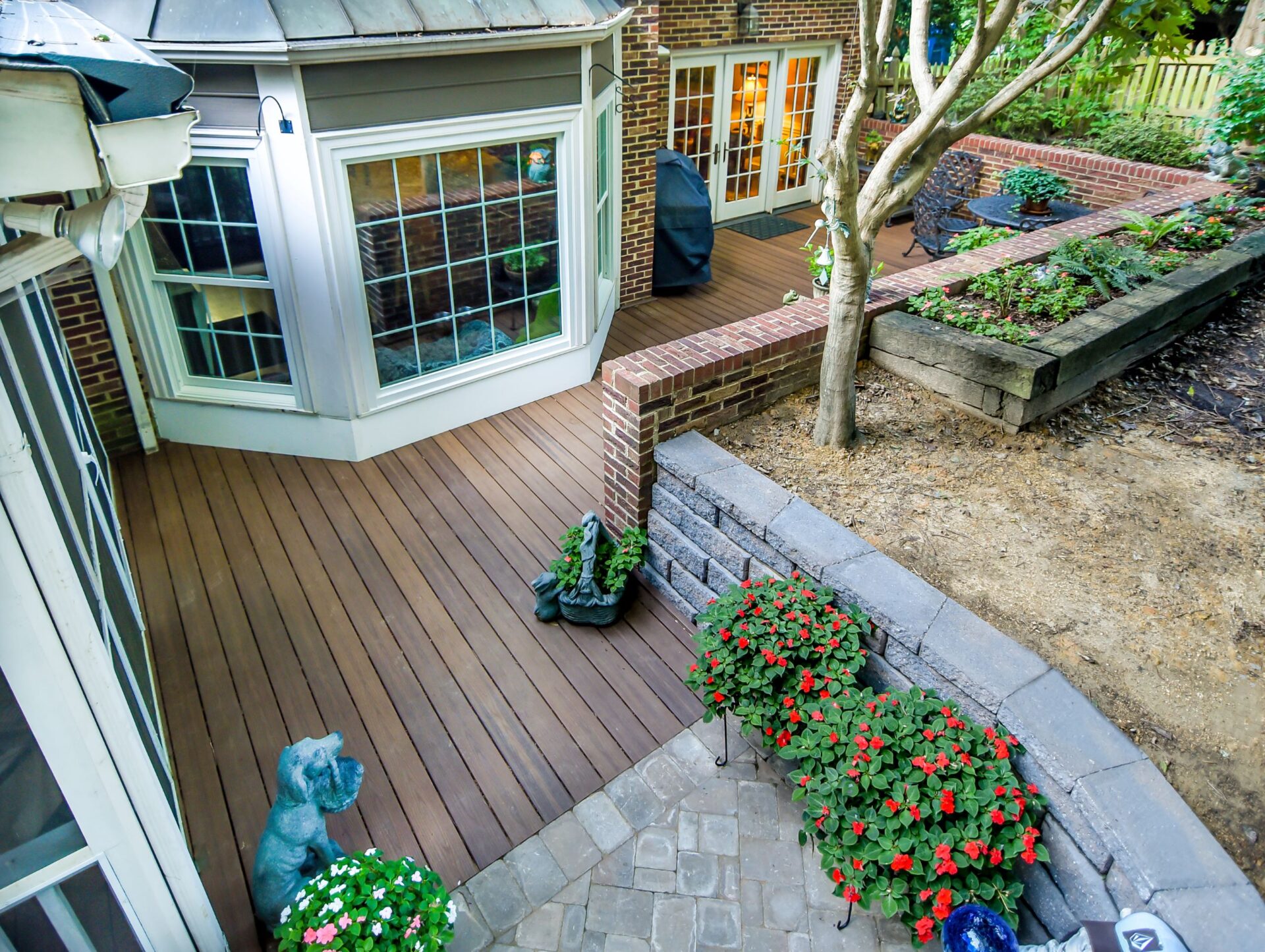 Expansive composite deck with brick and block retaining walls, and paver accent patio, custom built by Carolina Decks in the Pineville, NC area.