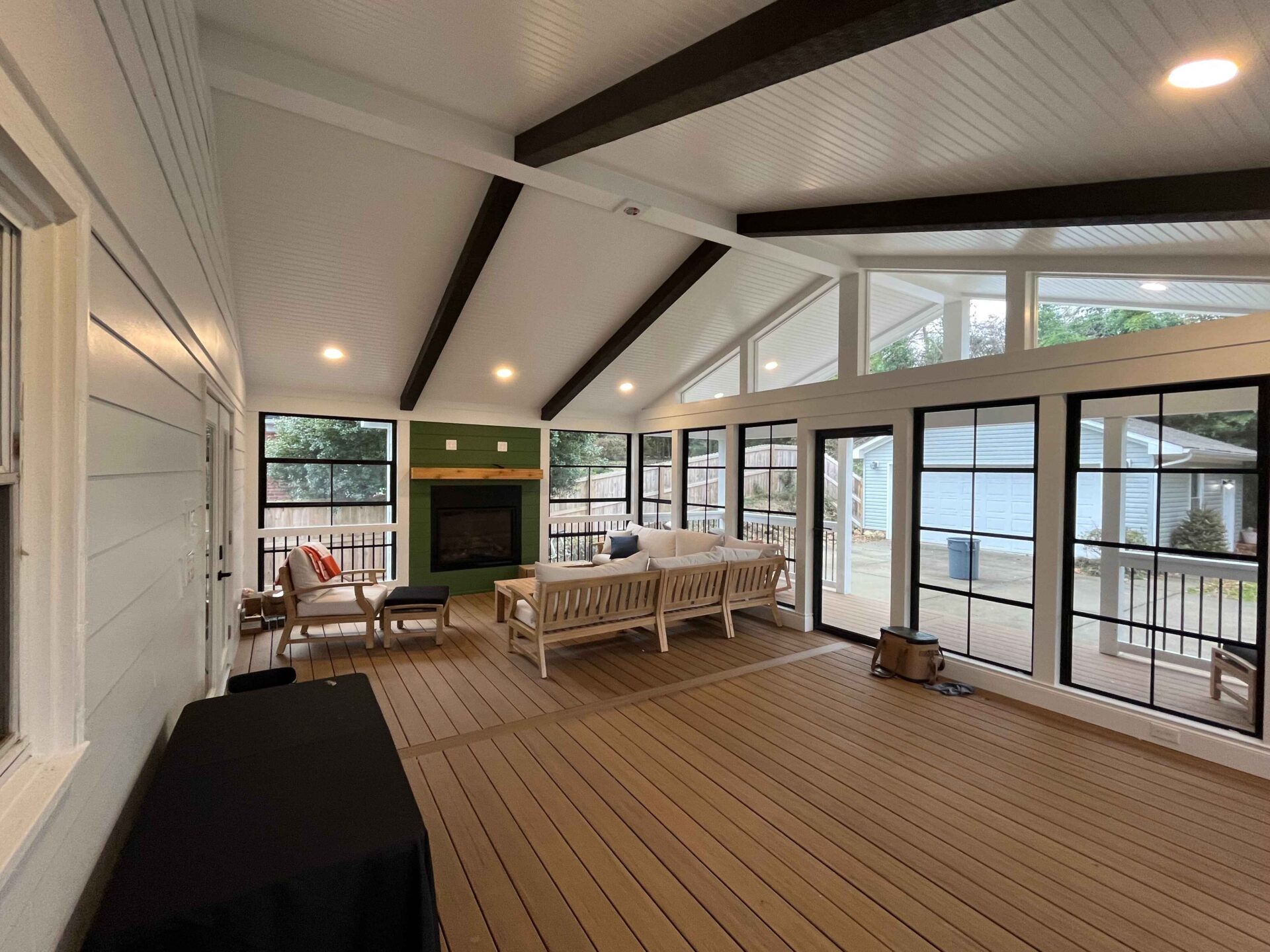 View from an elevated covered porch extension looking down toward a concrete driveway and detached garage at a home in Matthews, North Carolina.