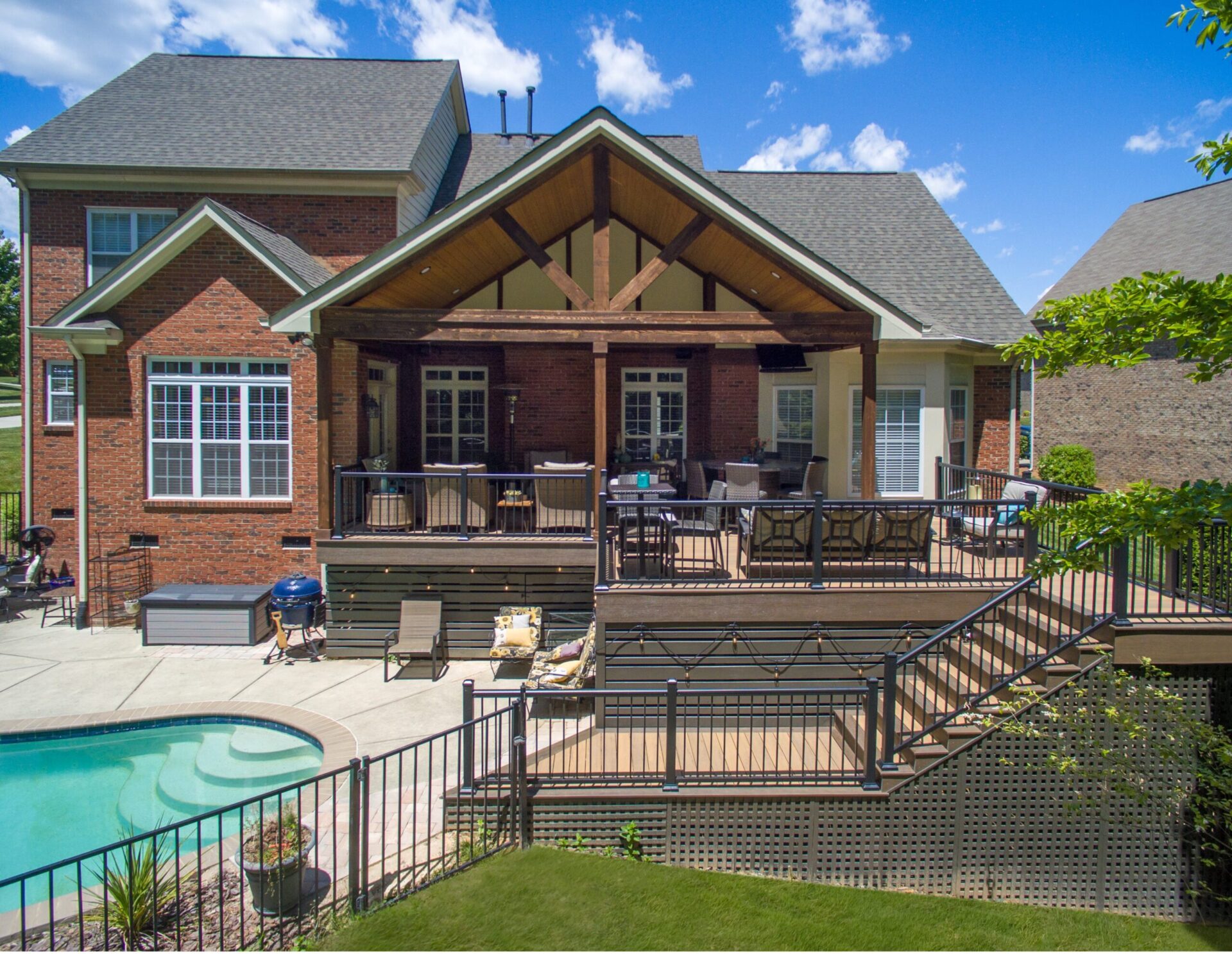 Full exterior view of a brick home featuring a custom gabled porch addition by Carolina Decks in Poplar Forest.