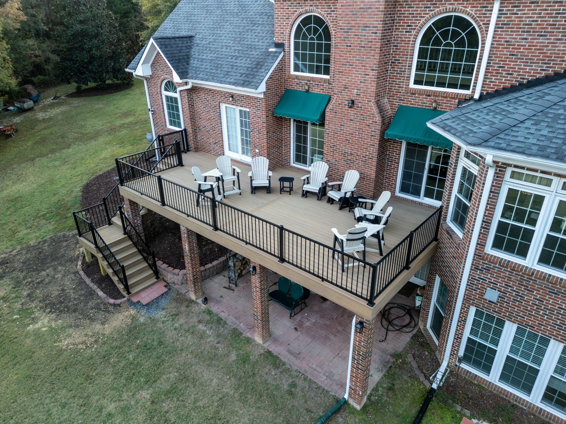 Elevated composite deck with sleek black aluminum railings and a paver patio underneath, custom built by Carolina Decks in the Lake Wylie neighborhood.