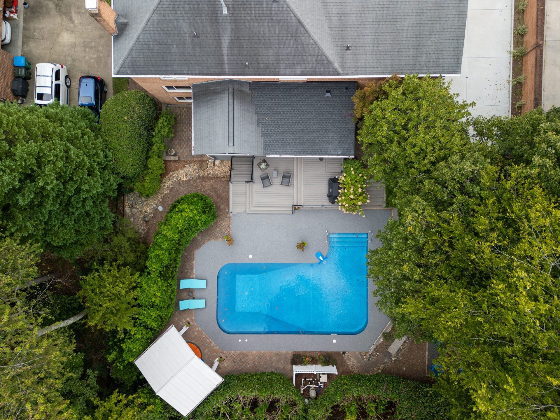 Multi-level composite deck, light gray pool surround, and paver walkways, custom built by Carolina Decks in the South Charlotte, NC area.