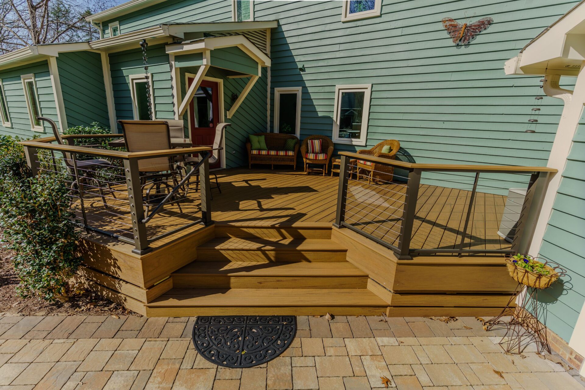 Multi-level composite deck with cable railing and paver patio, custom built by Carolina Decks in the Belmont neighborhood.
