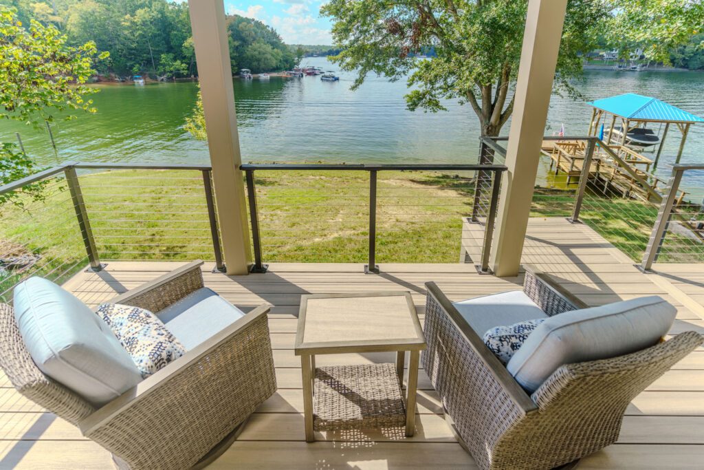Composite deck with sleek cable railing, comfy outdoor seating, and beautiful lake views, custom built by Carolina Decks in Tega Cay.