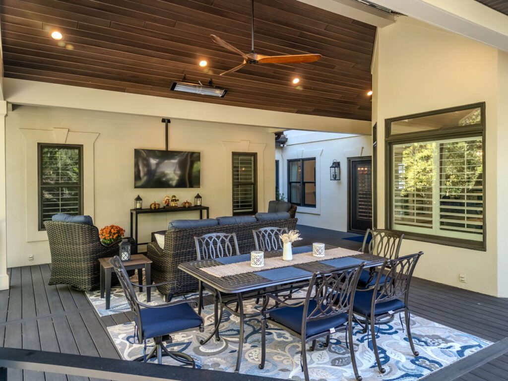 Spacious dark composite deck with elegant wood plank ceiling, outdoor lighting, and lounge area, custom built by Carolina Decks in the Providence Plantation neighborhood.