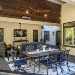 Spacious dark composite deck with elegant wood plank ceiling, outdoor lighting, and lounge area, custom built by Carolina Decks in the Providence Plantation neighborhood.
