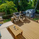 Composite deck with dark metal railings and a lounging area, custom built by Carolina Decks in the Meyers Park, NC area.