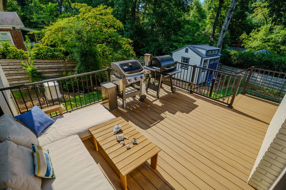 Composite deck with dark metal railings and a lounging area, custom built by Carolina Decks in the Meyers Park, NC area.
