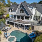 Luxurious multi-level deck, paver patio, swimming pool, and outdoor fireplace with custom stone accents, custom built by Carolina Decks in the Lake Norman, NC area.