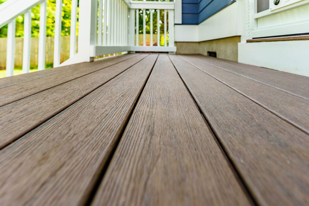 Detailed brown textured composite decking boards and clean white railings, custom built by Carolina Decks in the Charlotte, NC area.