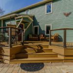 Multi-level composite deck with modern cable railing and paver patio, custom built by Carolina Decks in the Belmont, NC area.
