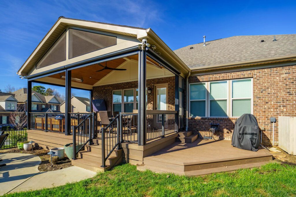 Spacious multi-level composite deck with black railings and a vaulted screened porch with wood ceiling, custom built by Carolina Decks in the Skybrooke neighborhood.
