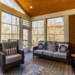 Bright sunroom with vaulted wood ceiling, large windows, and composite deck flooring, custom built by Carolina Decks in the Waxhaw, NC area.