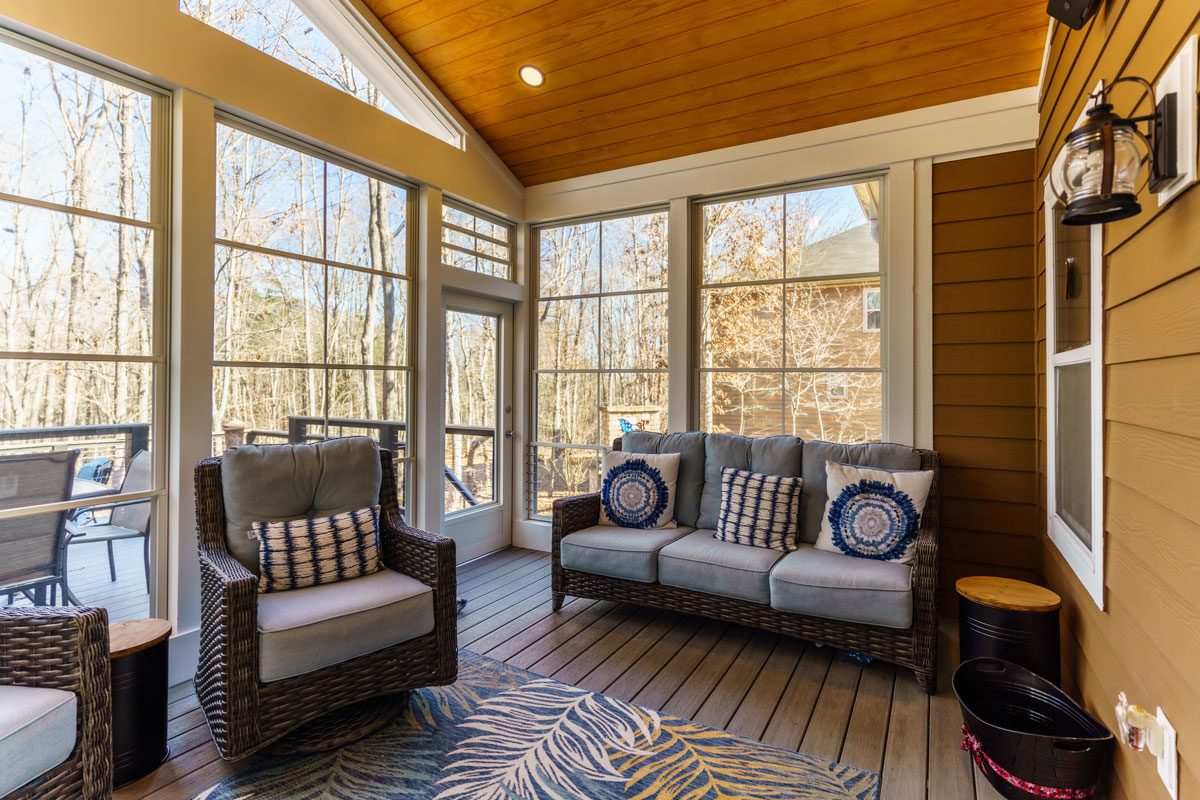 Bright sunroom with vaulted wood ceiling, large windows, and composite deck flooring, custom built by Carolina Decks in the Waxhaw, NC area.