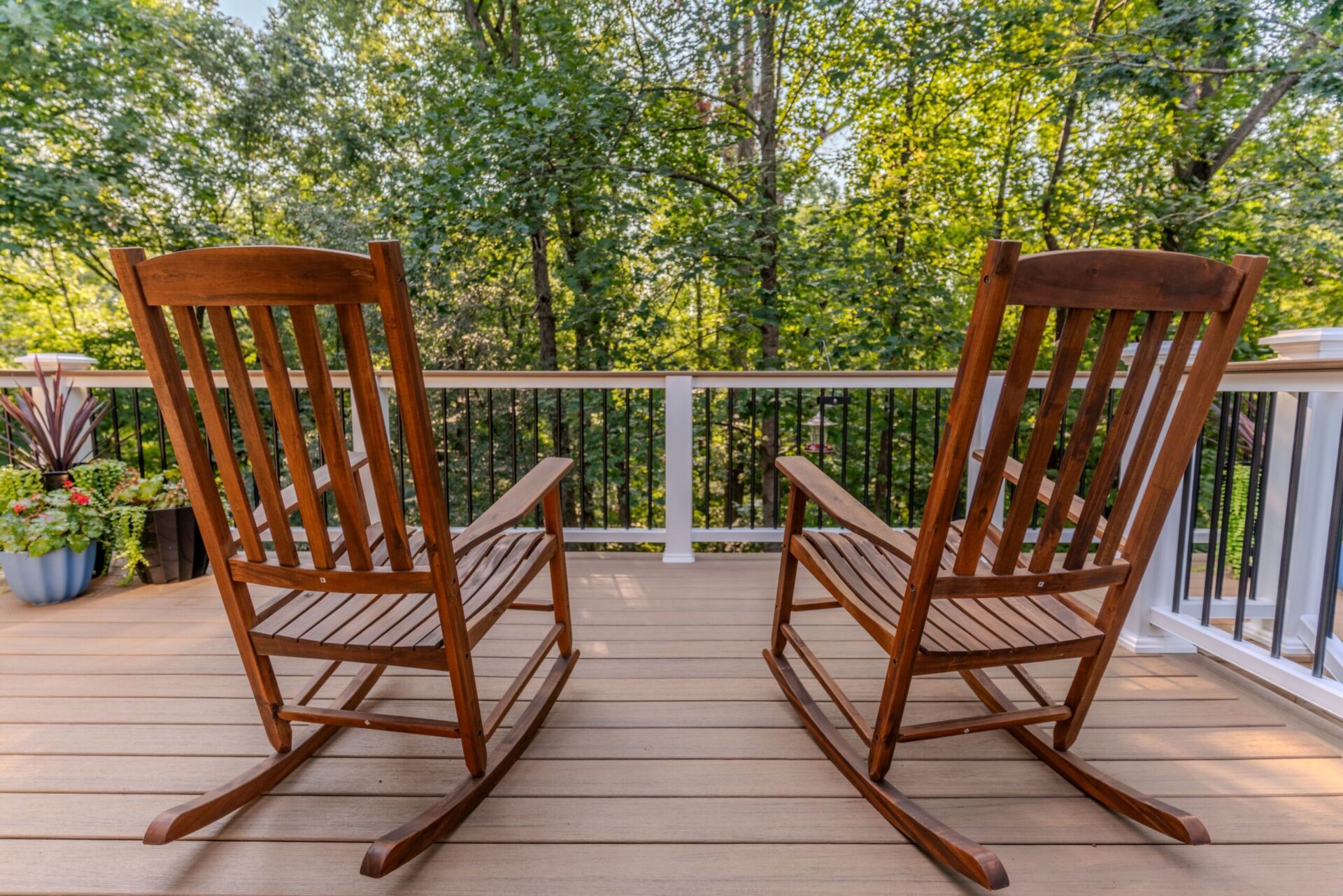 Light brown composite deck with white railing and black balusters, perfect for relaxing, custom built by Carolina Decks in the Sardis Forest neighborhood.