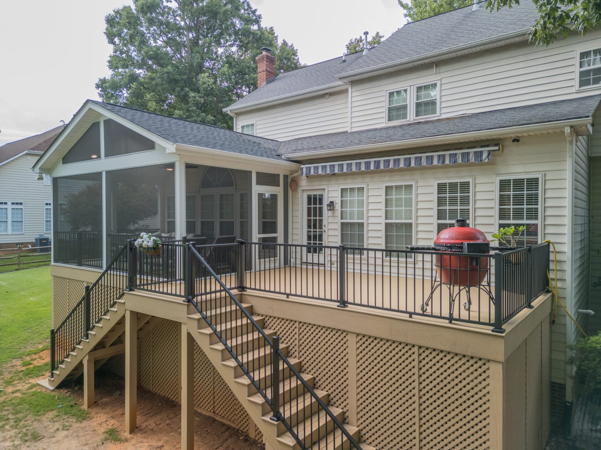 Expansive multi-level tan composite deck with black aluminum railing and screened porch addition, custom built by Carolina Decks in the Plaza Midwood neighborhood.