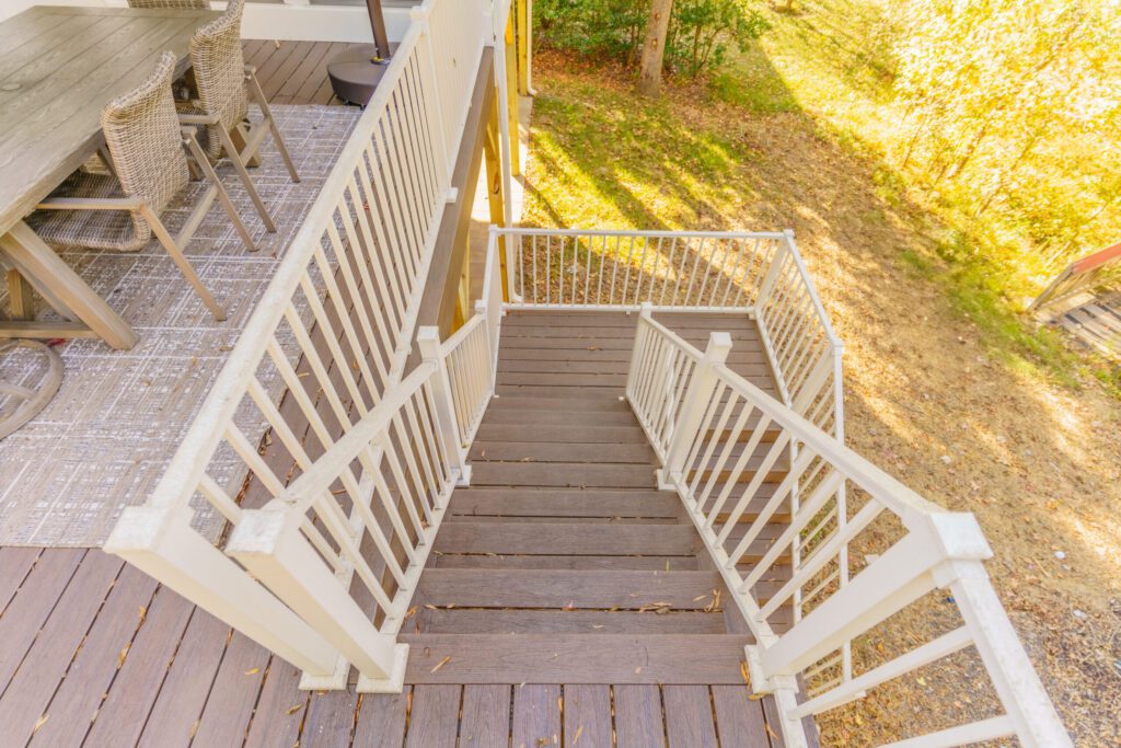 Overhead view of a multi-level composite deck in Charlotte, NC, featuring white aluminum railings and wide stairs for a low-maintenance backyard solution.
