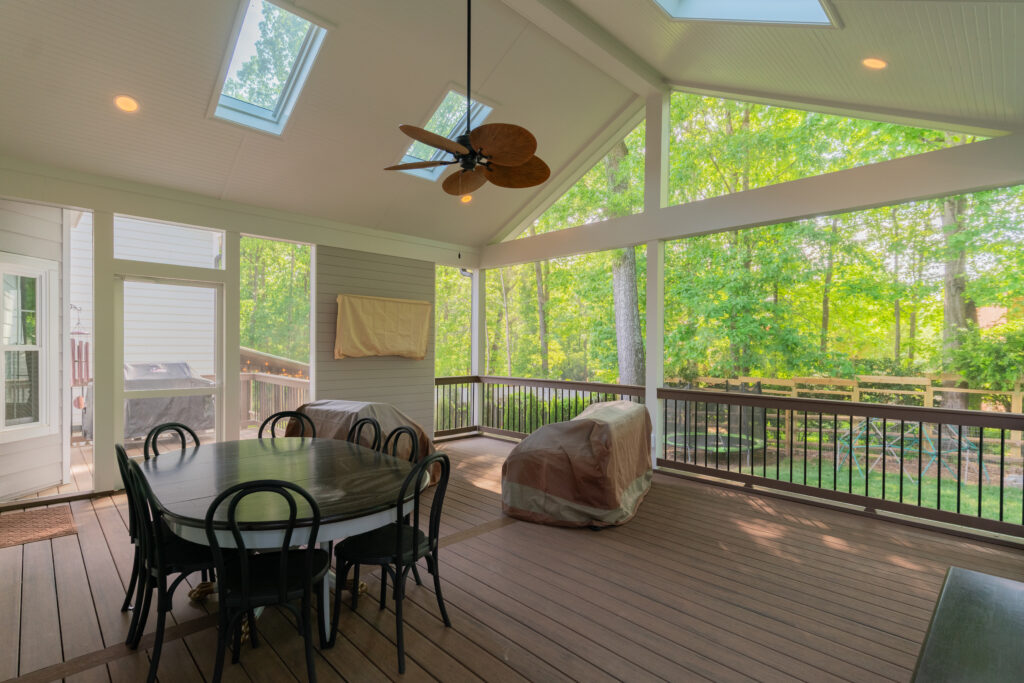 Spacious Screeneze screened-in porch in Providence Plantation, Southeast Charlotte, featuring a gray accent feature wall, vaulted ceiling with skylights, and premium composite decking in TechPrime and Dark Roast.