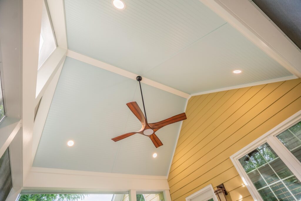 Custom vaulted screen porch ceiling featuring integrated recessed lighting, a modern ceiling fan, and premium trim.