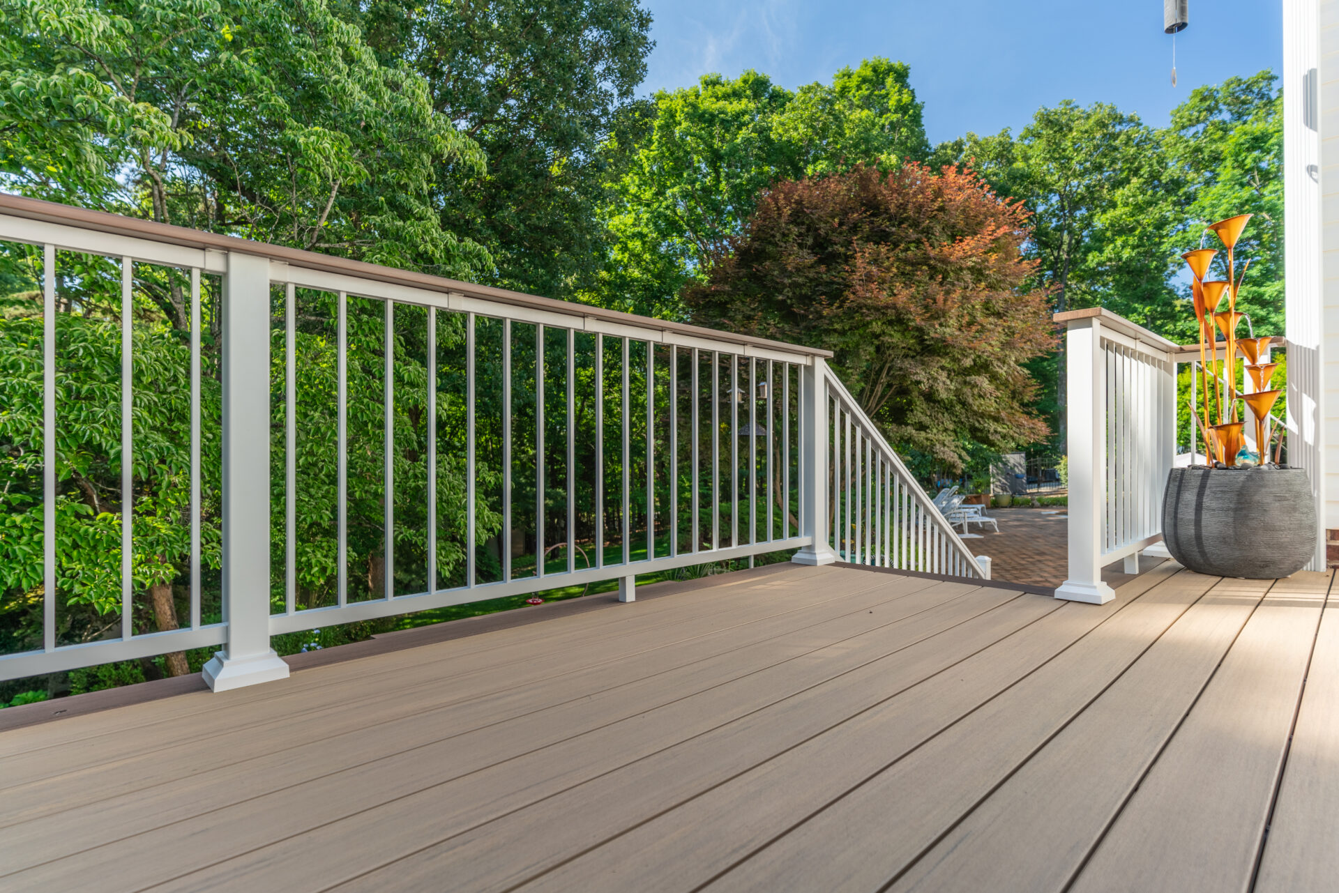 imberTech English Walnut composite decking with white Impression Rail Express powder-coated aluminum railings on a custom build.