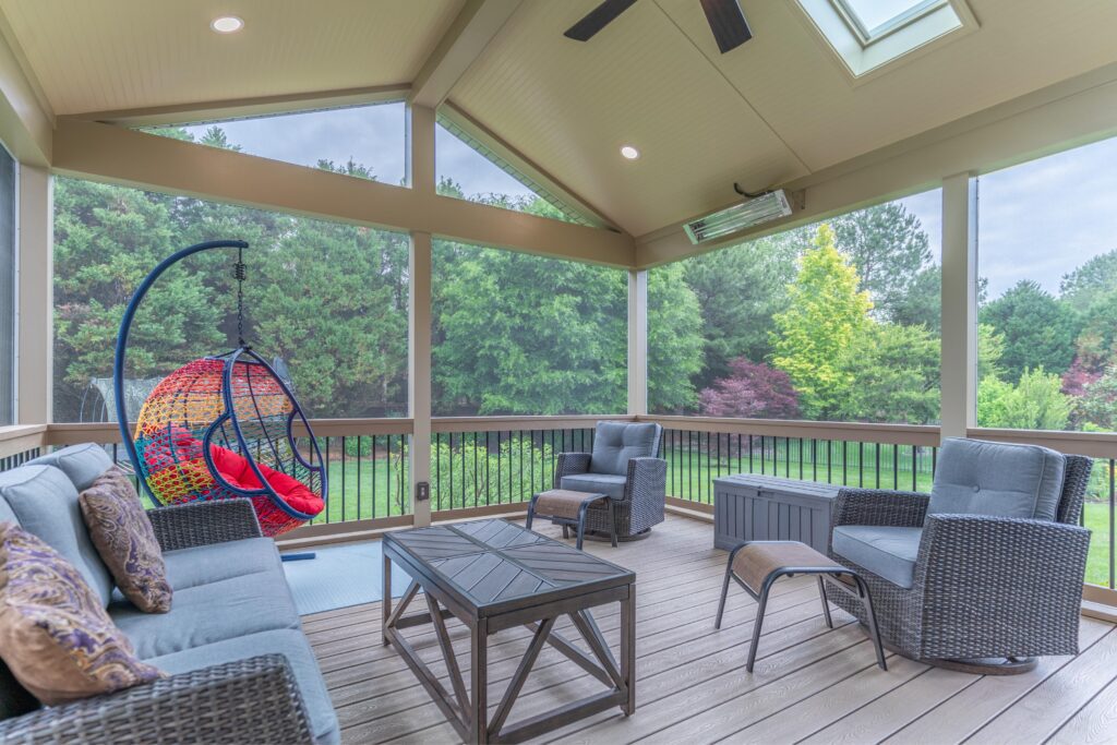 Interior of a custom screened porch featuring a modern seating area, premium composite flooring, a Screeneze system, and wall-mounted Infratech heaters.