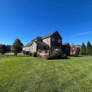 An aging, open wood deck on a brick home prior to being converted into a custom screened porch.