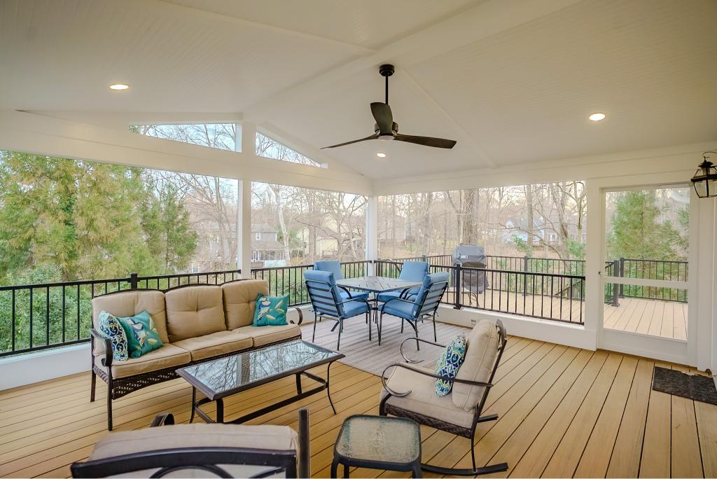 Open-concept Eze-Breeze 3-season screened porch with tile flooring and a ceiling fan on a custom deck addition in South Charlotte.