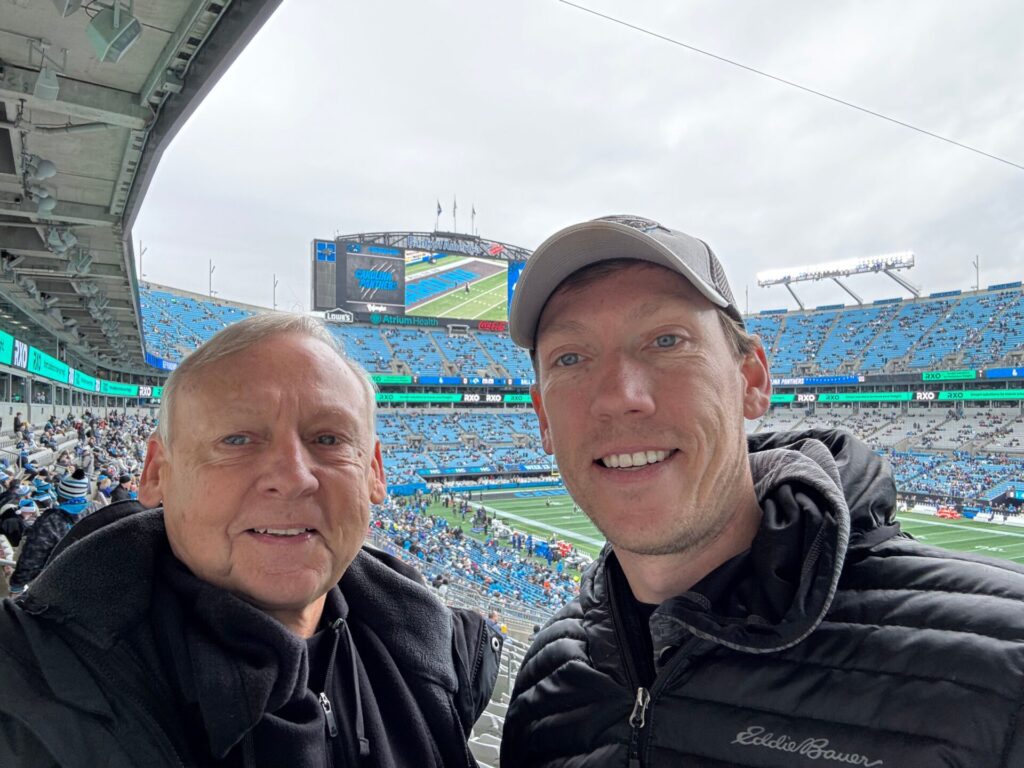 Luke at a Fall football game with his dad, both longtime University of Alabama fans.