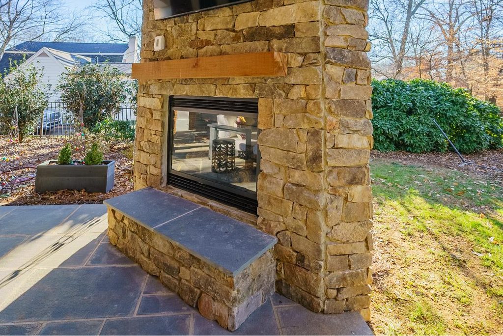 Outdoor stone fireplace with blue flagstone hearth and mantel built on a patio in SouthPark, Charlotte, NC